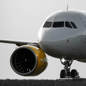 A commercial airliner with yellow turbine on the runway at Schiphol Airport, showcasing aviation engineering.