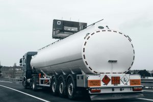 Rear view of a large tanker truck transporting fuel on a highway, emphasizing logistics and transportation.